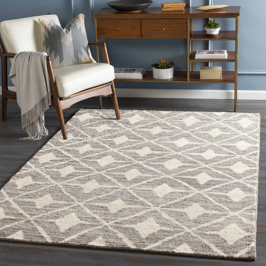 Living room scene with a Brooksburg Area Rug in dark brown and ivory, styled with a chair and wood console table. Roomscene-Rectangle