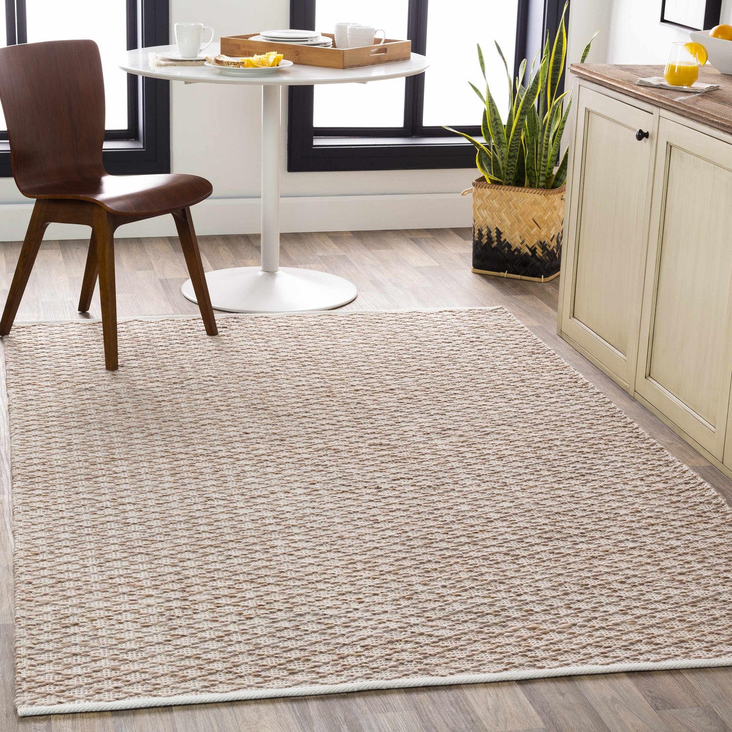 Bright kitchen scene with a Brillion Area Carpet, round table, wood chair, and neutral cabinets. Roomscene-Rectangle