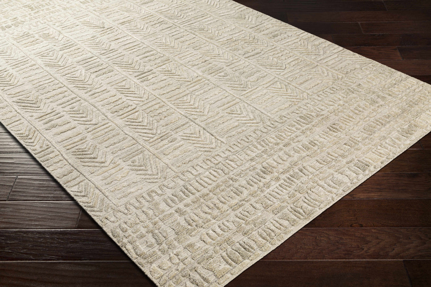 Close-up of the Burlington Clearance Rug showing its oatmeal color and geometric, hand-loomed pattern on dark wood flooring. Corner