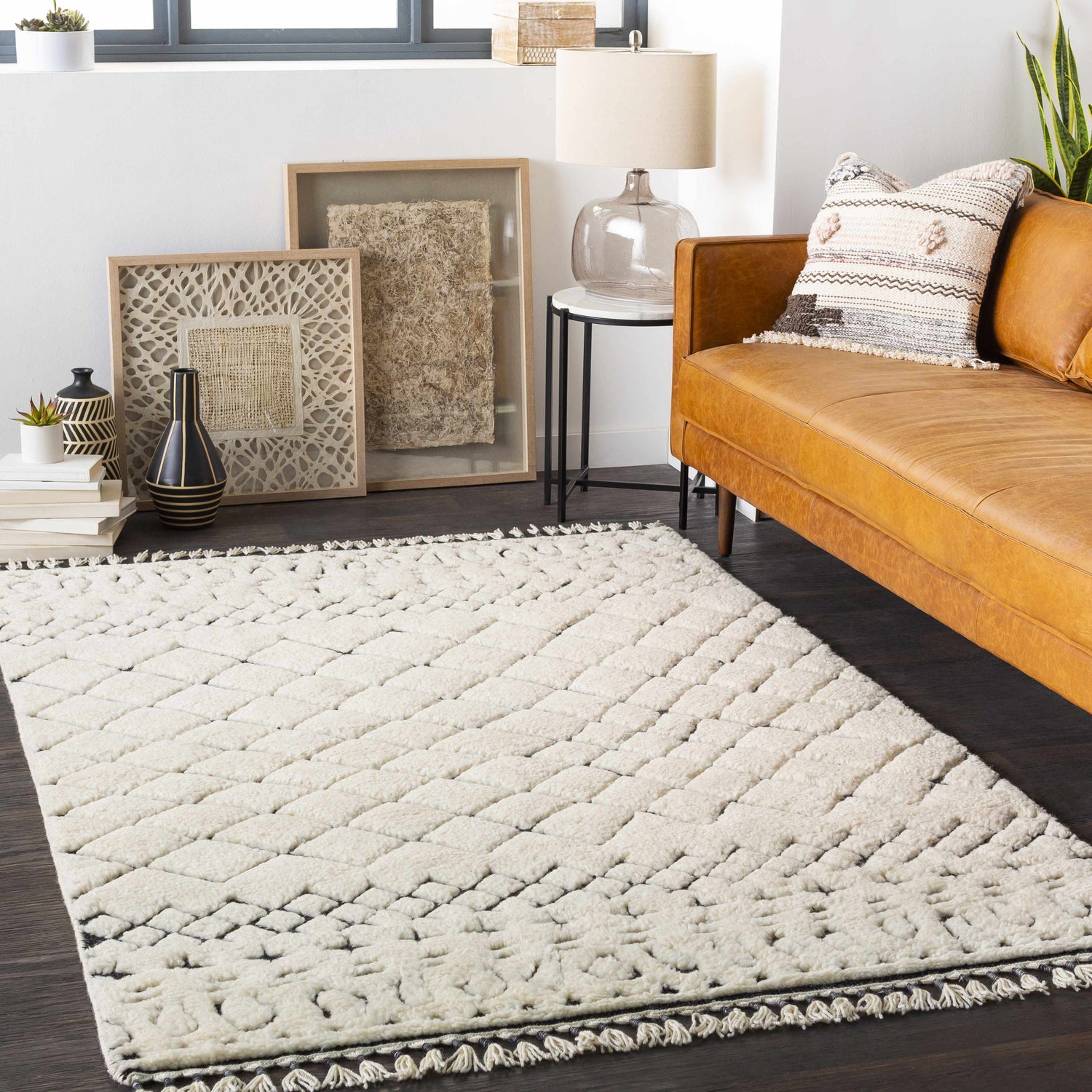 Living room scene with a cream and black Brundall Clearance Rug, tan leather sofa, and neutral decor. Roomscene-Rectangle