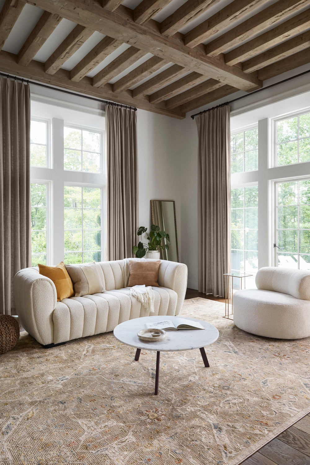 Living room with a cream sofa, round chair, and Barneyside Luxe Area Rug in tan, cream, and brick red tones. Roomscene-Rectangle