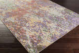Close-up of the Bronxville Area Rug showing its dark brown, lavender, lilac, olive, and peach abstract design. Corner