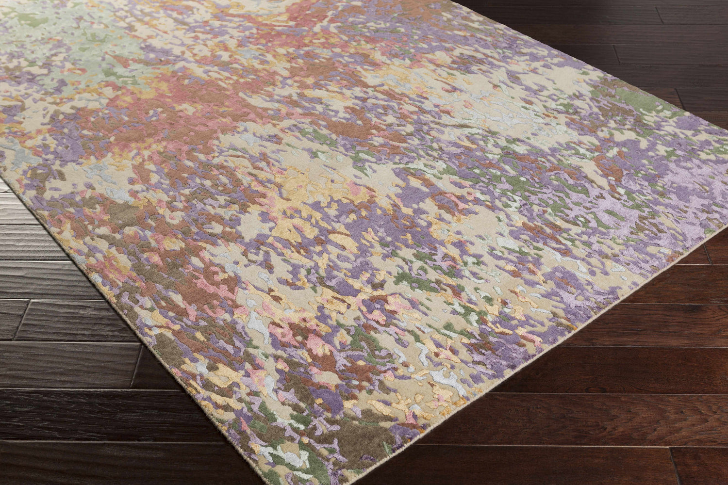 Close-up of the Bronxville Area Rug showing its dark brown, lavender, lilac, olive, and peach abstract design. Corner