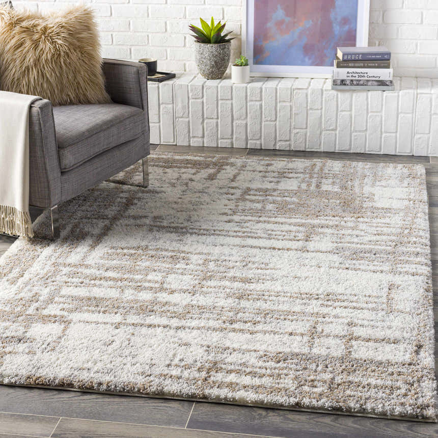 Living room scene with cream Broulee Abstract Striped Plush Rug, gray chair, and white brick fireplace. Roomscene-Rectangle