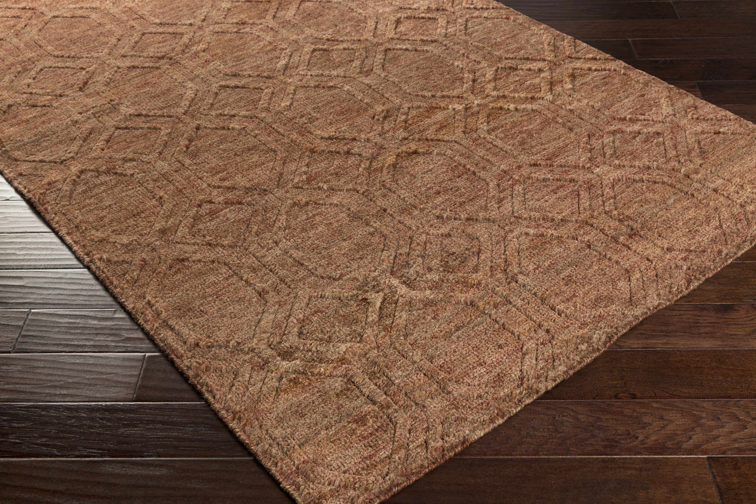 Close-up of the brick red Bartlett Jute Rug showing its hand-knotted texture and geometric pattern. Corner
