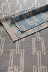 Close-up of Brundidge Area Carpet. Hand-woven wool rug with a gray and ivory geometric chain pattern. Contemporary style. Styleshot