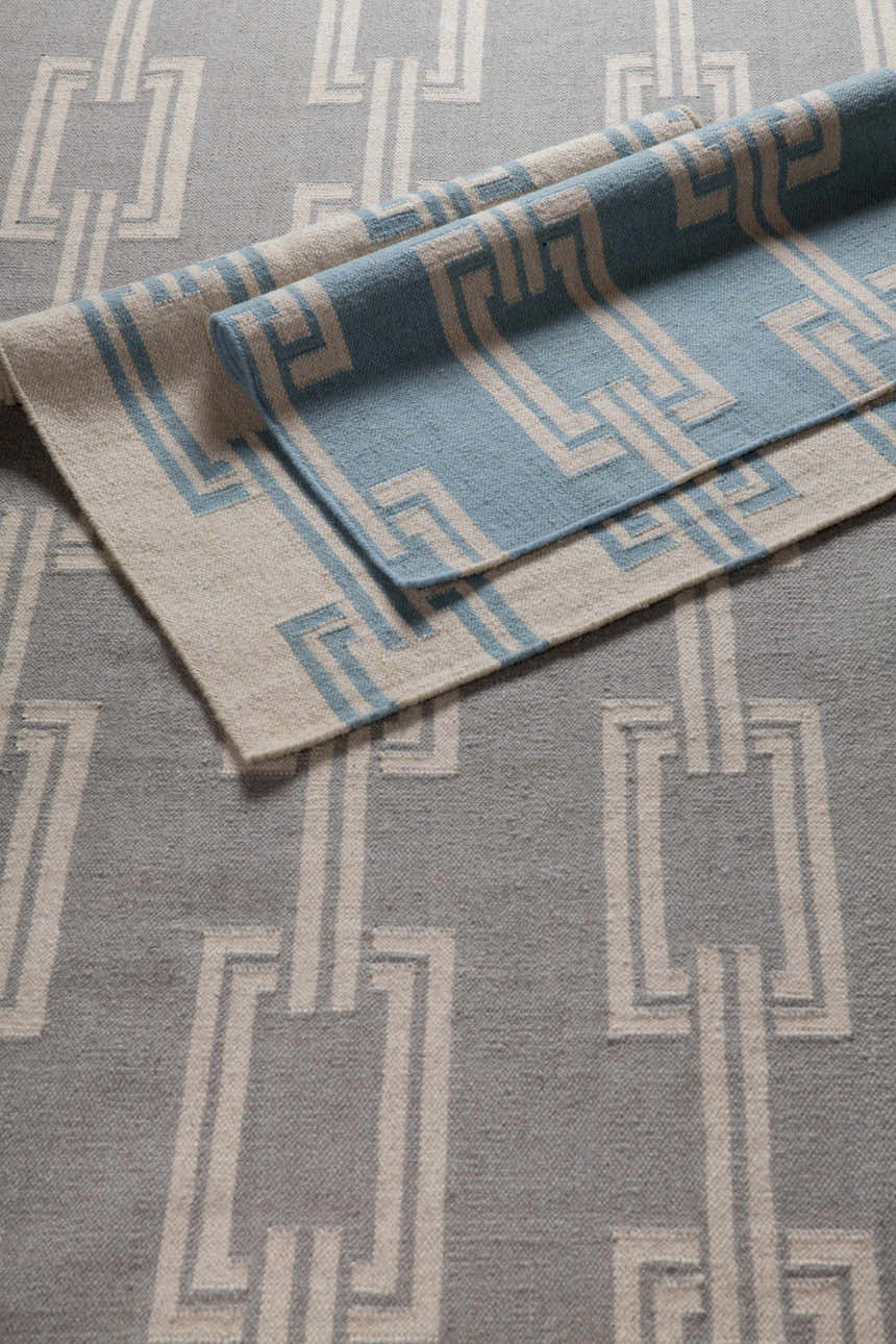 Close-up of Brundidge Area Carpet. Hand-woven wool rug with a gray and ivory geometric chain pattern. Contemporary style. Styleshot