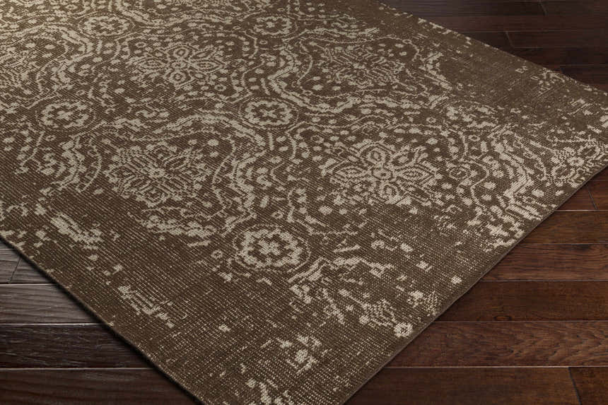 Close-up of the Bryce Area Rug, a hand-knotted wool rug with a traditional brown and beige floral pattern. Corner