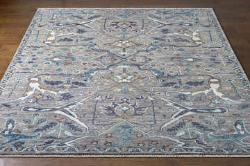 Detailed view of the hand-knotted Bugasan Area Rug. Gray, teal, plum, and brown tones. Bohemian style. Front