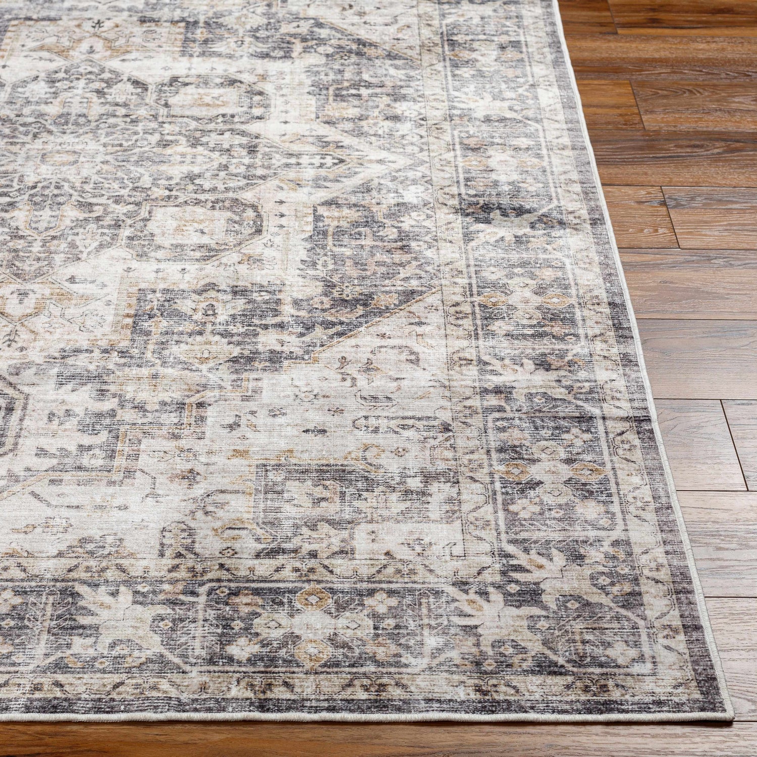 Close-up of the Bevin Washable Area Rug, a farmhouse style rug with a traditional gray, brown, and taupe pattern. Front