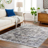 Living room scene with a neutral sofa and the gray and brown Bevin Washable Area Rug on a wood floor. Roomscene-Rectangle