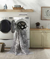 Laundry room scene with Bevin Washable Area Rug emerging from a front load washer. Farmhouse style with gray and brown tones. Washing-Machine