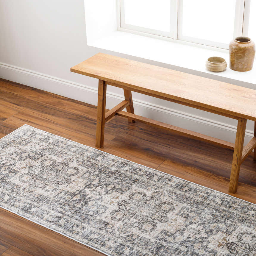 Hallway scene with a gray Bevin Washable Area Rug, wood bench, wood floors, and natural light from a window. Roomscene-Runner