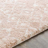 Close-up of the Blush Plush Area Rug showing its soft texture, blush and cream colors, and subtle pattern. Texture