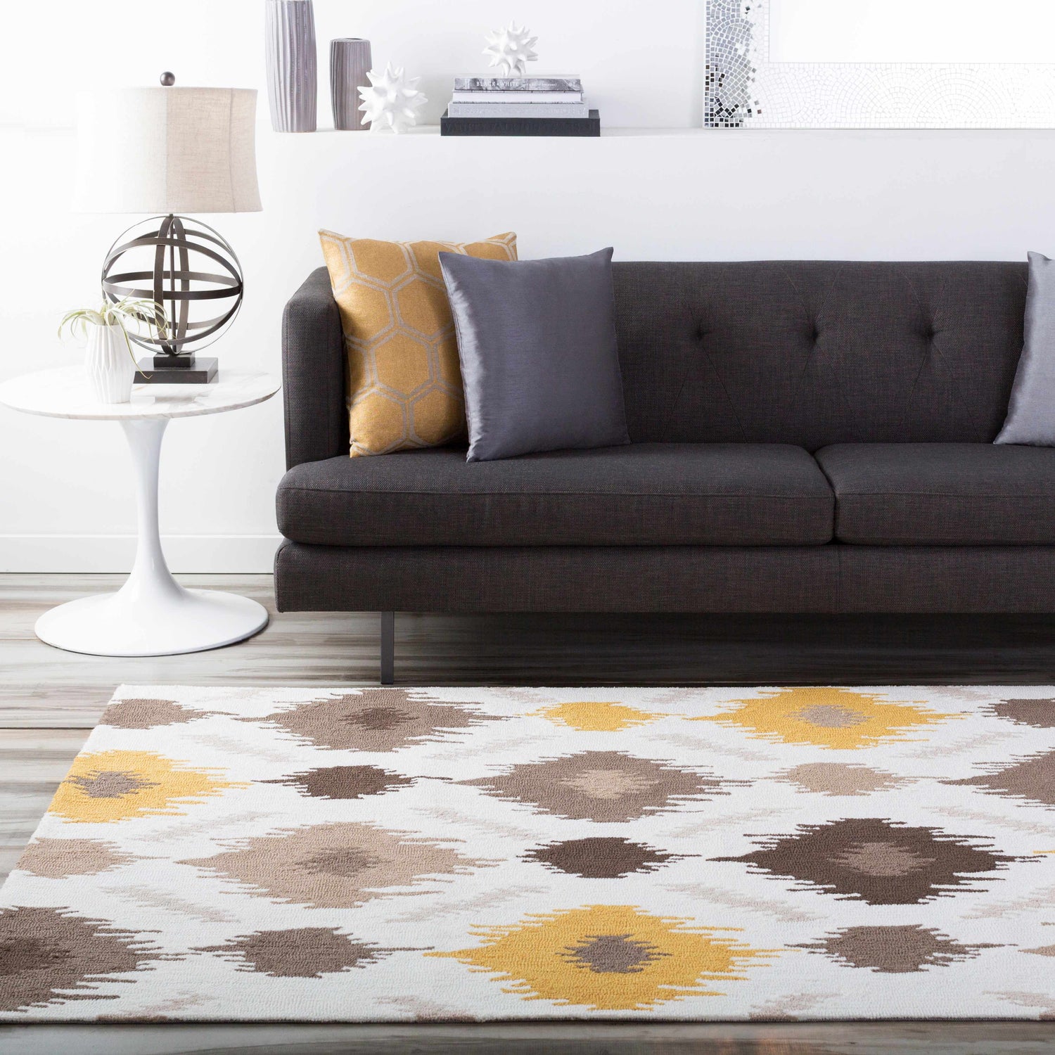Living room scene with a Byhalia Area Rug in beige, brown, and mustard colors under a gray sofa. Roomscene-Rectangle