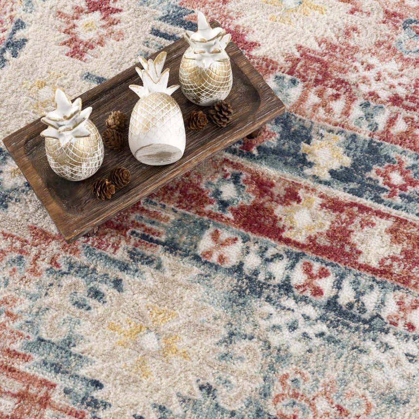 Close-up of Bindi Blue & Rose Area Rug showing Southwestern design, blue, rose, and cream colors, and textured weave. Styleshot