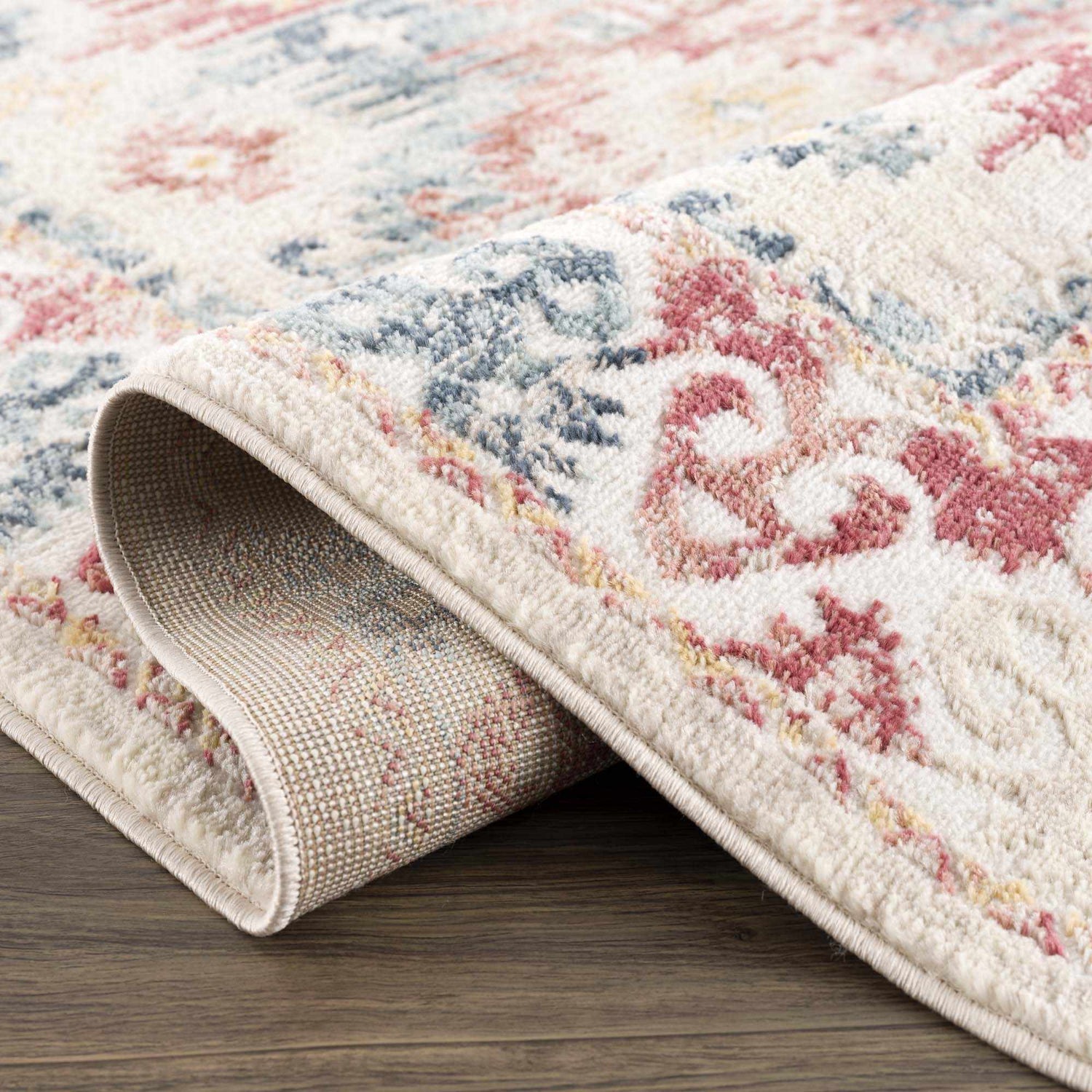 Close-up of the Bindi Blue & Rose Area Rug showing its Southwestern, vintage design, blue and rose colors, and soft texture. Fold