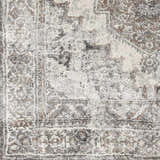 Close-up of the luxe Manaring Charcoal area rug. Features a traditional pattern in charcoal, cream, gray, and brown tones. Swatch