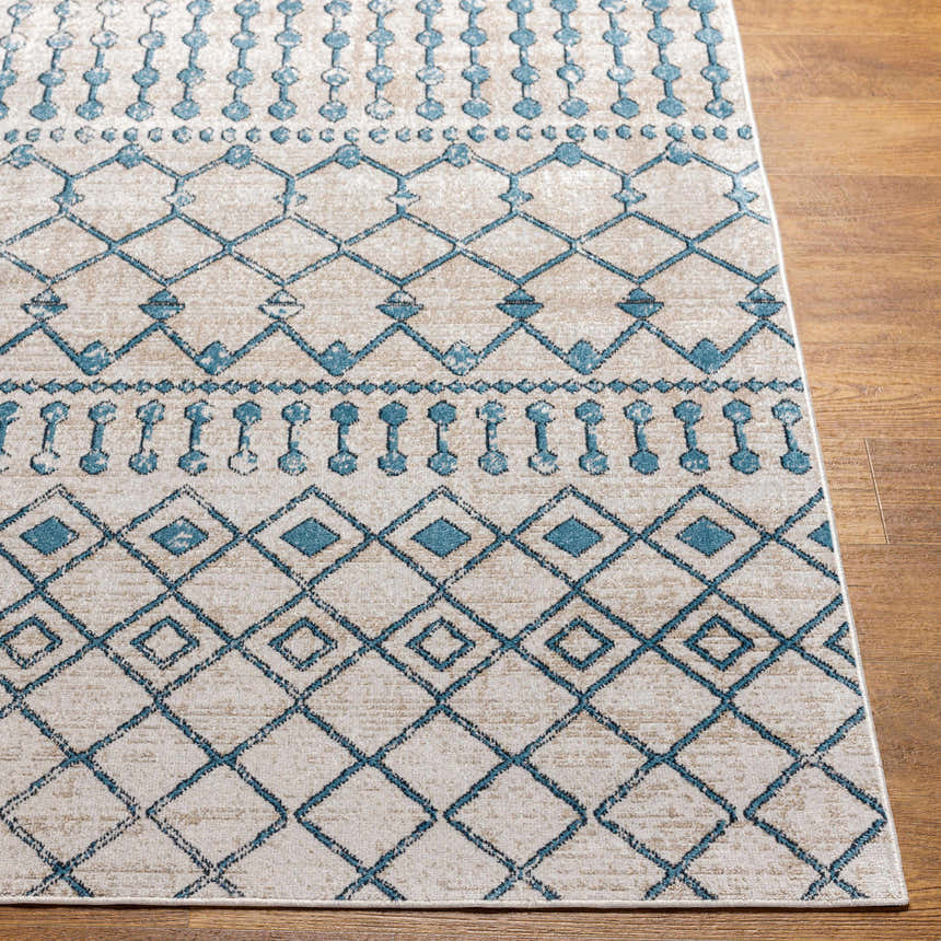 Close-up of the Cabognon Washable Area Rug. Features a geometric pattern in blue, ink blue, light beige, and light gray. Front