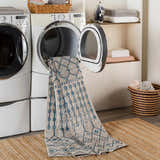 Laundry room scene with a blue and beige Cabognon Washable Area Rug coming out of the dryer. Jute rug on the floor. Washing-Machine