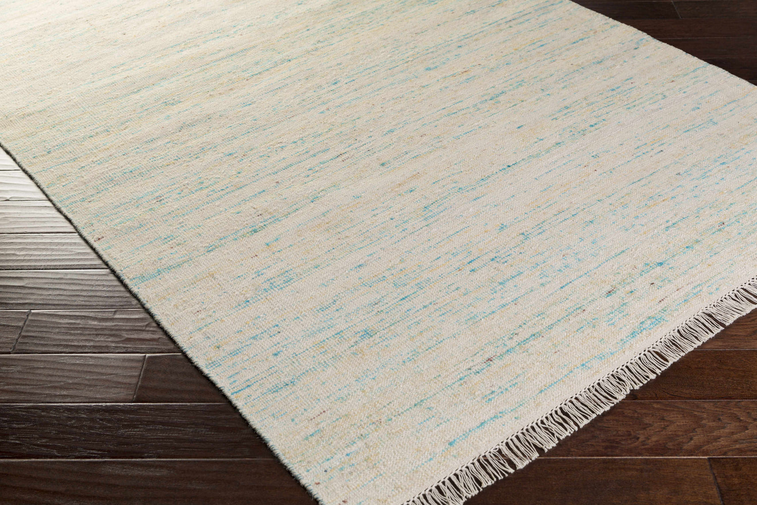 Close-up of the hand-woven Cairnbrook Area Carpet; aqua, blue, and pale blue stripes on a cream background with fringe detail. Corner