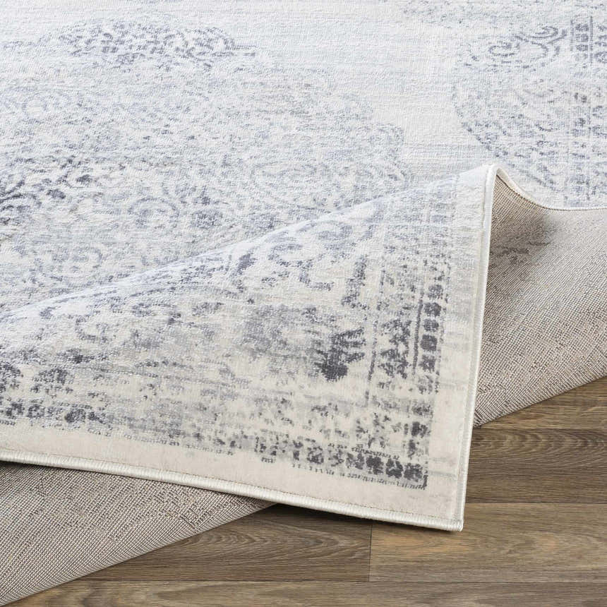 Close-up of the Caloundra Area Rug showing its charcoal, gray, and white oriental design and machine-woven texture. Fold