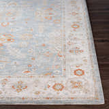 Close-up of the Camrose Thick Luxe Statement Rug, showing its light blue, beige, and orange traditional floral pattern. Front