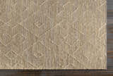 Close-up of the Carine Jute Area Rug showing beige color and geometric diamond pattern with textured, hand-woven construction. Corner