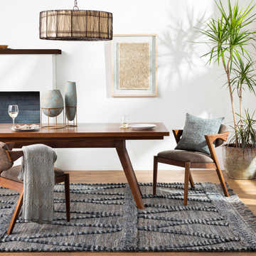 Dining room with a Caromatan Premium Handmade Wool Rug in gray, wood table, chairs, and a potted plant. Roomscene-Rectangle
