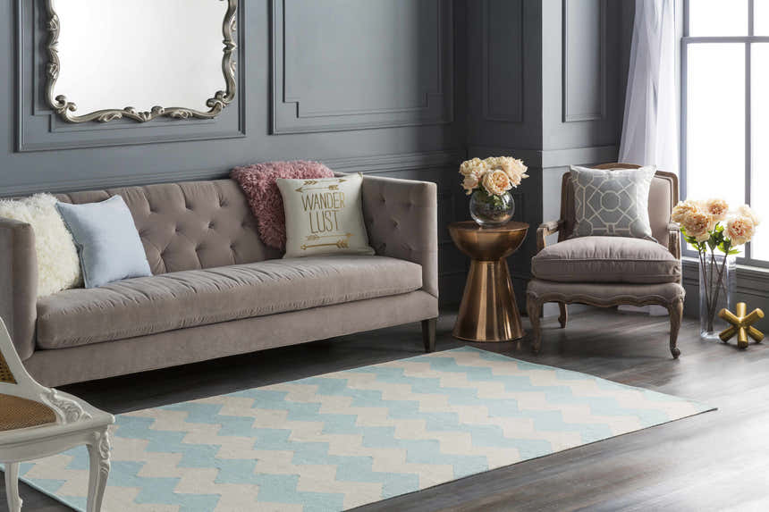Living room scene with a blue and ivory Caswell Area Rug, gray sofa, and accent chair. Roomscene-Rectangle