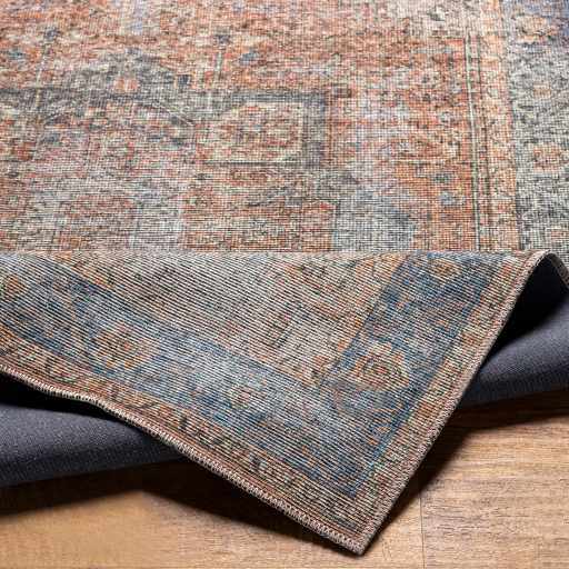 Close-up of the Cayanguan Area Rug showing its traditional pattern, blue, brown, and gray colors, and woven texture. Fold
