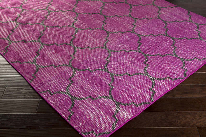 Fuchsia Cedarburg Area Rug on dark wood floor. Contemporary wool rug with black geometric pattern. Clearance rug. Corner