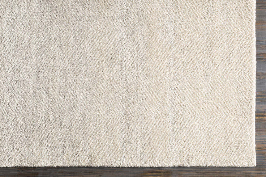 Close-up of the Ceiba Carpet in beige and ivory, showing its hand-knotted texture and wool-viscose blend. Corner