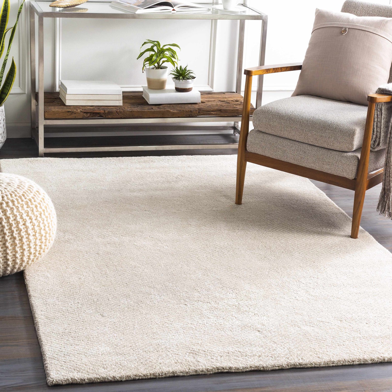 Living room scene with a beige Ceiba Carpet, gray chair, and modern metal and wood console table. Roomscene-Rectangle