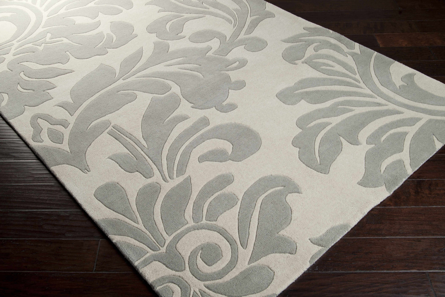 Close-up of the Cementon Area Rug. Gray floral pattern on ivory wool rug. Hand-tufted texture. Corner