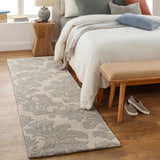 Bedroom scene with a gray and ivory Cementon Area Rug runner, wood floors, and a bed with neutral pillows. Roomscene-Runner
