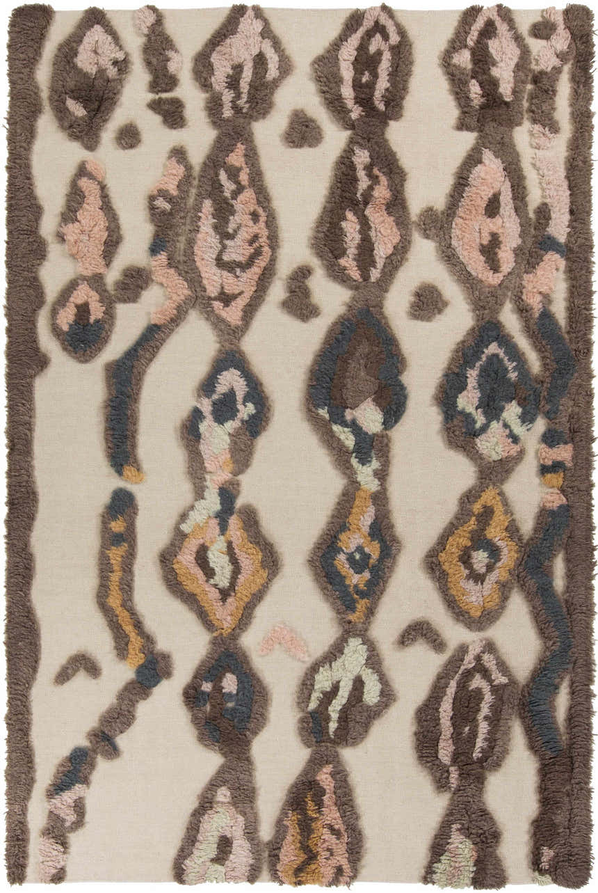 Close-up of the Brown Pink Nila Area Carpet. Hand-woven wool rug with beige background and brown, pink, and blue geometric shag design. Design-Rectangle-58