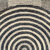 Close-up of Chantesuta Modern Wool Rug. Beige and black concentric semi-circles pattern. Hand-tufted texture. Swatch