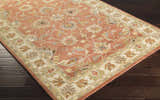 Close-up of the Caesar Hand Tufted Burnt Orange 1124 Wool Carpet. Features floral pattern in brick red, brown, and blue hues. Corner