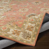 Close-up of the Caesar Hand Tufted Burnt Orange 1124 Wool Carpet. Features floral design, brick red, and taupe colors. Fold