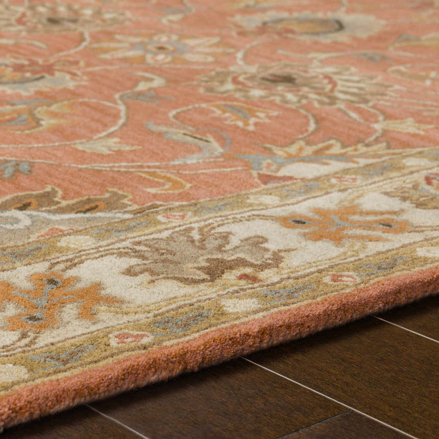 Close-up of the hand-tufted Caesar Burnt Orange Wool Rug. Features a traditional floral pattern in burnt orange, brown, and taupe. Texture