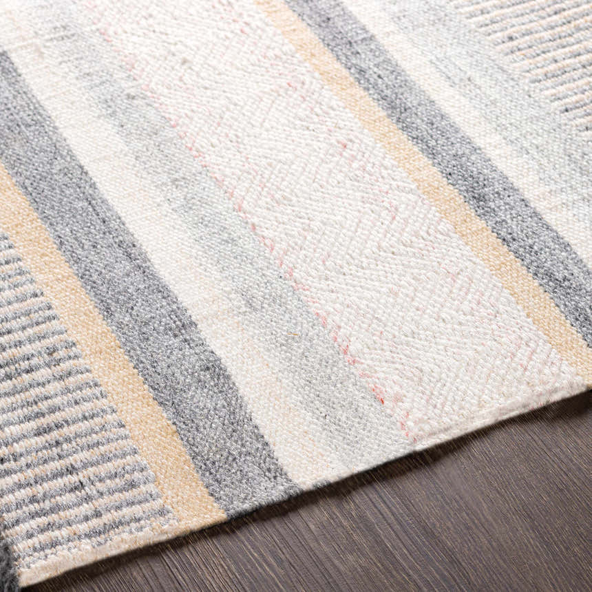 Close-up of the Charlemagne Flatweave Performance Rug showing its charcoal, cream, beige, and gray striped pattern. Texture
