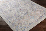 Close-up of Aisha Abstract Premium Sheen Viscose Rug. Features blue, orange, and purple floral pattern on a taupe background. Corner