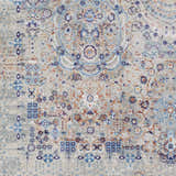 Close-up of Aisha Abstract Premium Sheen Viscose Rug with blue, burnt orange, and gray floral and geometric pattern. Swatch