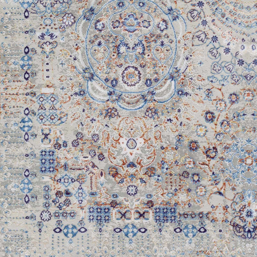 Close-up of Aisha Abstract Premium Sheen Viscose Rug with blue, burnt orange, and gray floral and geometric pattern. Swatch