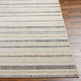 Close-up of Chato Area Rug showing bone, gray, nutmeg, and white thatch stripes on a wood floor. Geometric, coastal style. Front