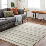 Living room scene with gray sofa and Chato Area Rug in bone, gray, and nutmeg. Coastal style rug on wood floor. Roomscene-Rectangle