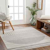 Entryway with a Cloud Gray Chet Area Rug, white chair, wood bench, and natural light. Roomscene-Rectangle