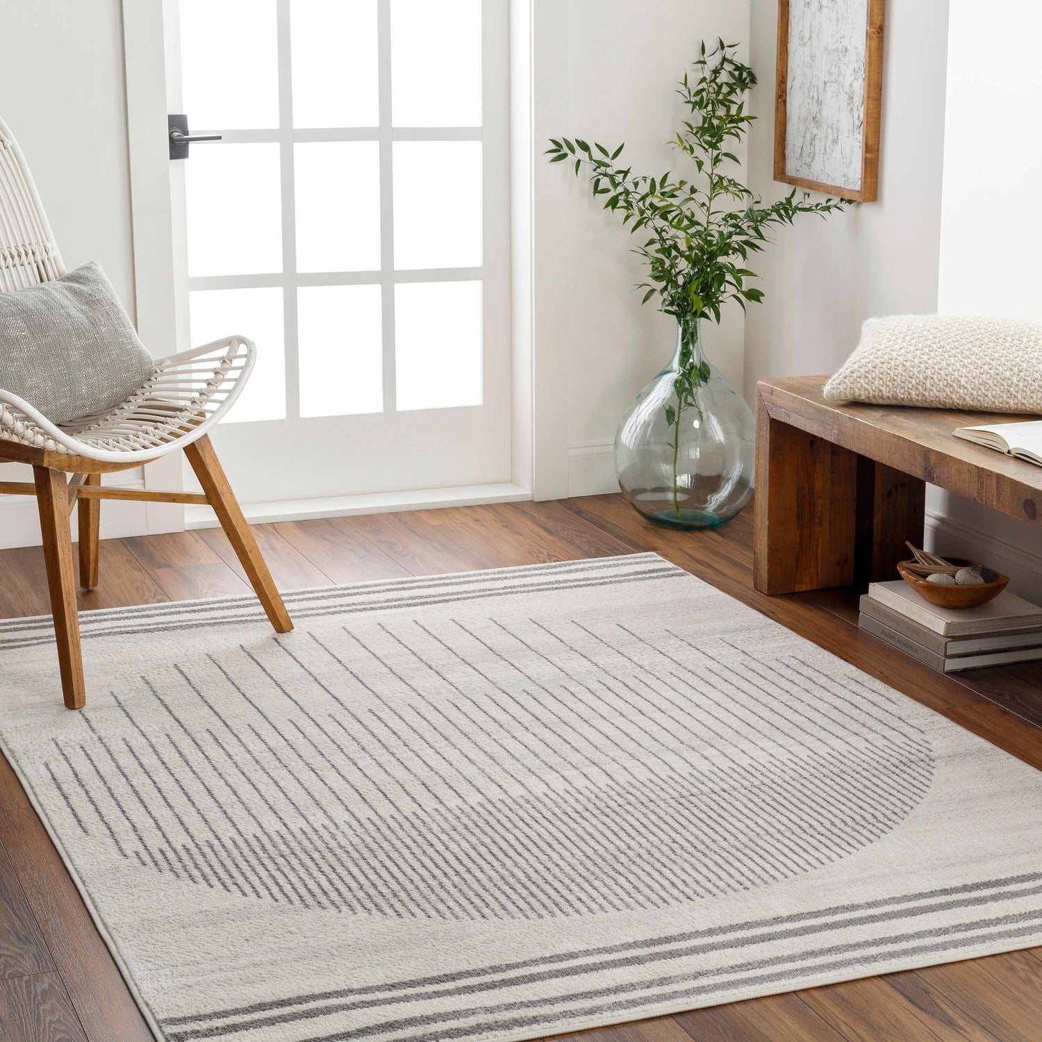 Entryway with a Cloud Gray Chet Area Rug, white chair, wood bench, and natural light. Roomscene-Rectangle