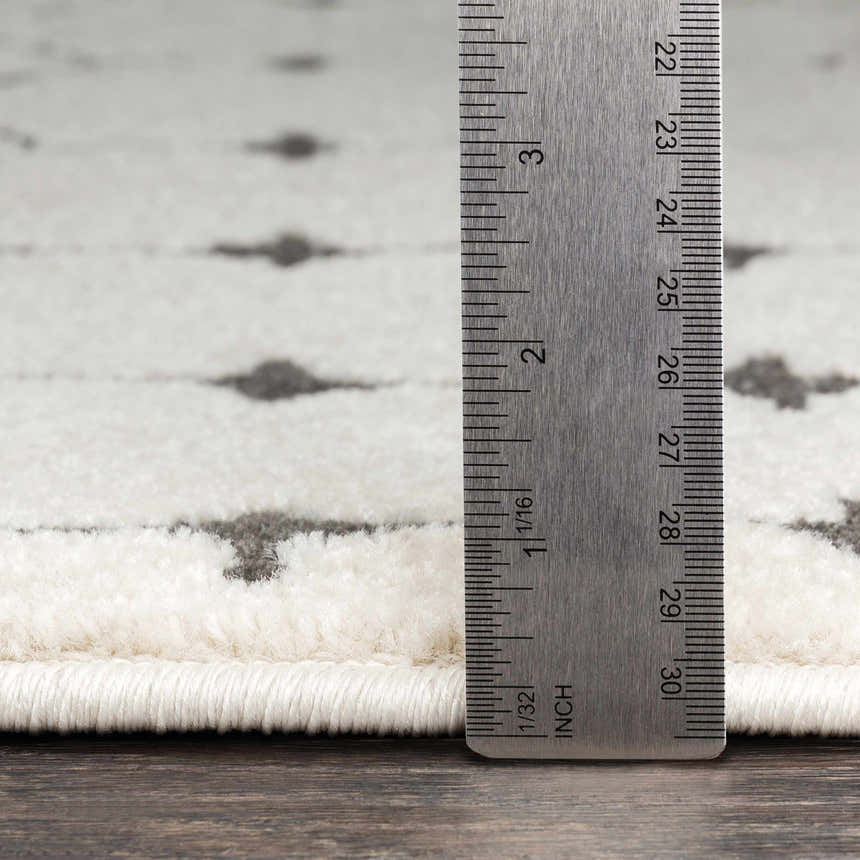 Close-up of Chubbuck Moroccan Trellis Rug pile height with ruler. Charcoal and light beige trellis pattern. Pile